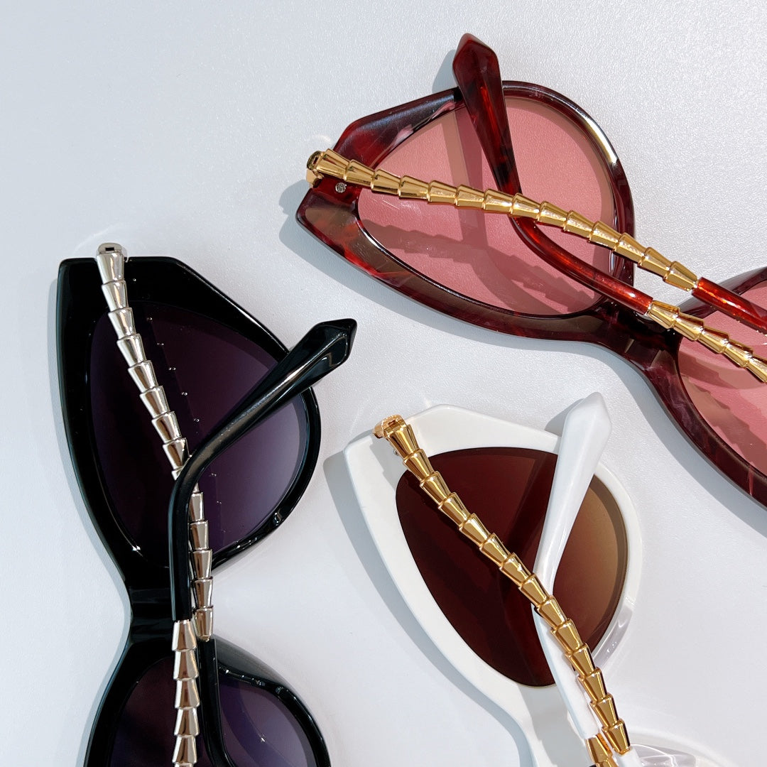 Cat-eye sunglasses set: red, black, and white frames with gold chain temples
