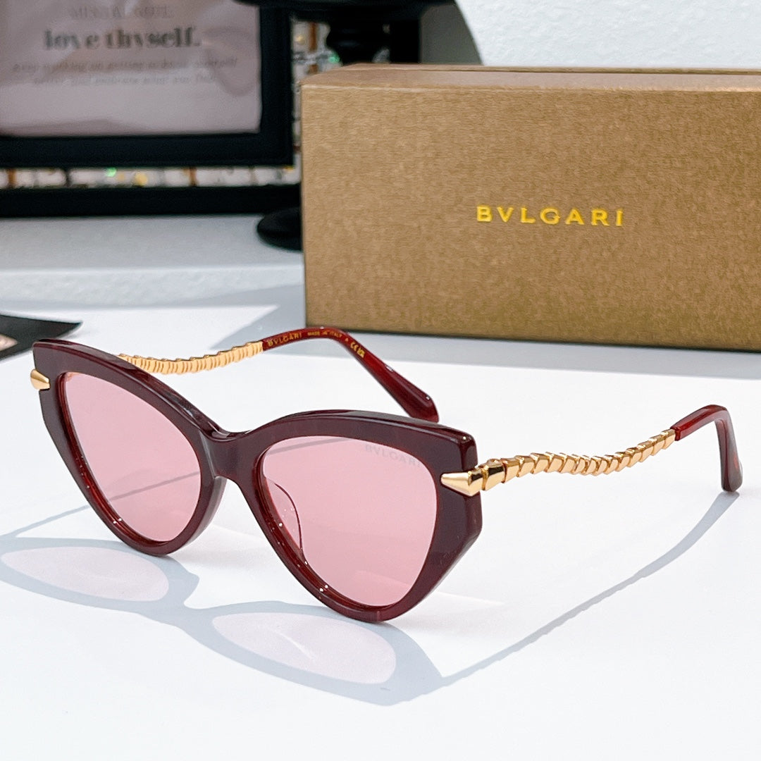 Cat-eye sunglasses with dark red frames, gold chain temples, pink-tinted lenses