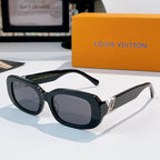 Louis Vuitton sunglasses with dark frame and smoke gradient lenses, gold logo hinges