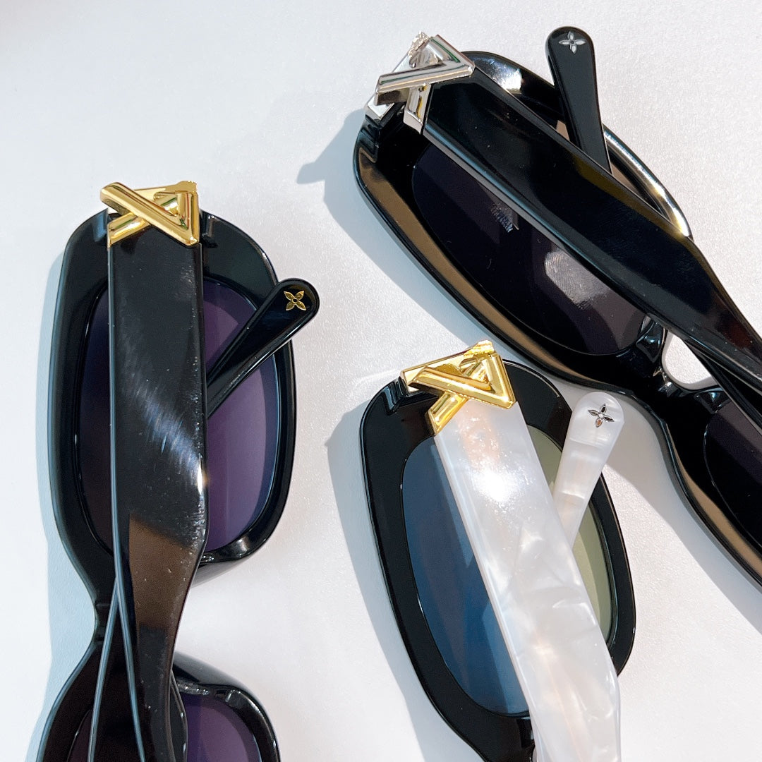 Louis Vuitton sunglasses close-up set with black frames and dark/clear lenses, gold emblems