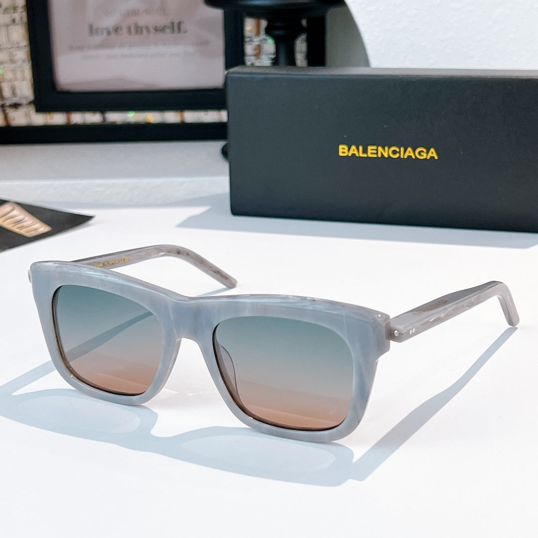 Balenciaga sunglasses with translucent light blue frame and tan tinted lenses