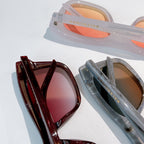 Balenciaga sunglasses pair with maroon and translucent frames and tinted lenses
