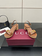 Gucci ladies tan heeled sandals with gold buckle straps and cork-look sole, angled view
