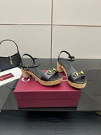 Black heeled sandals with gold buckle hardware and cork platform soles
