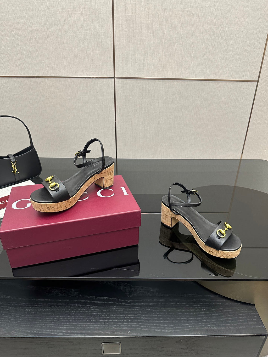Black platform sandals with gold buckle straps and cork wedge heel, side angle