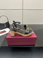 Black strappy platform sandals with gold ring hardware on cork heels