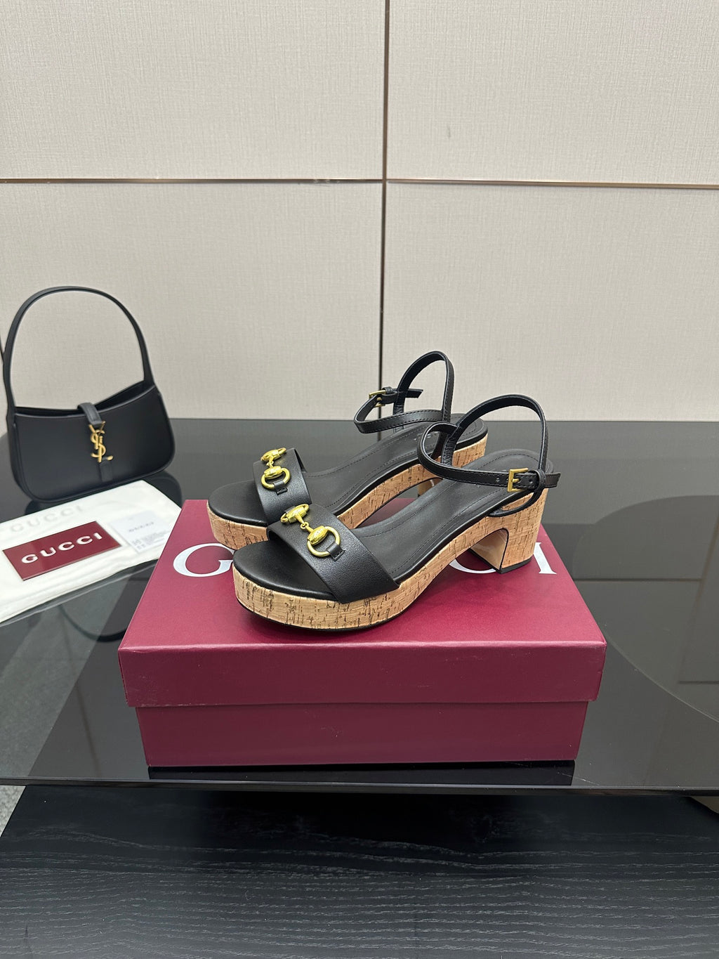 Pair of black platform sandals with gold rings on cork wedge heels