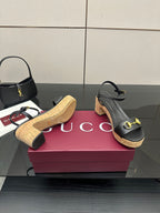 Black platform sandals with gold hardware and cork sole with a stacked heel
