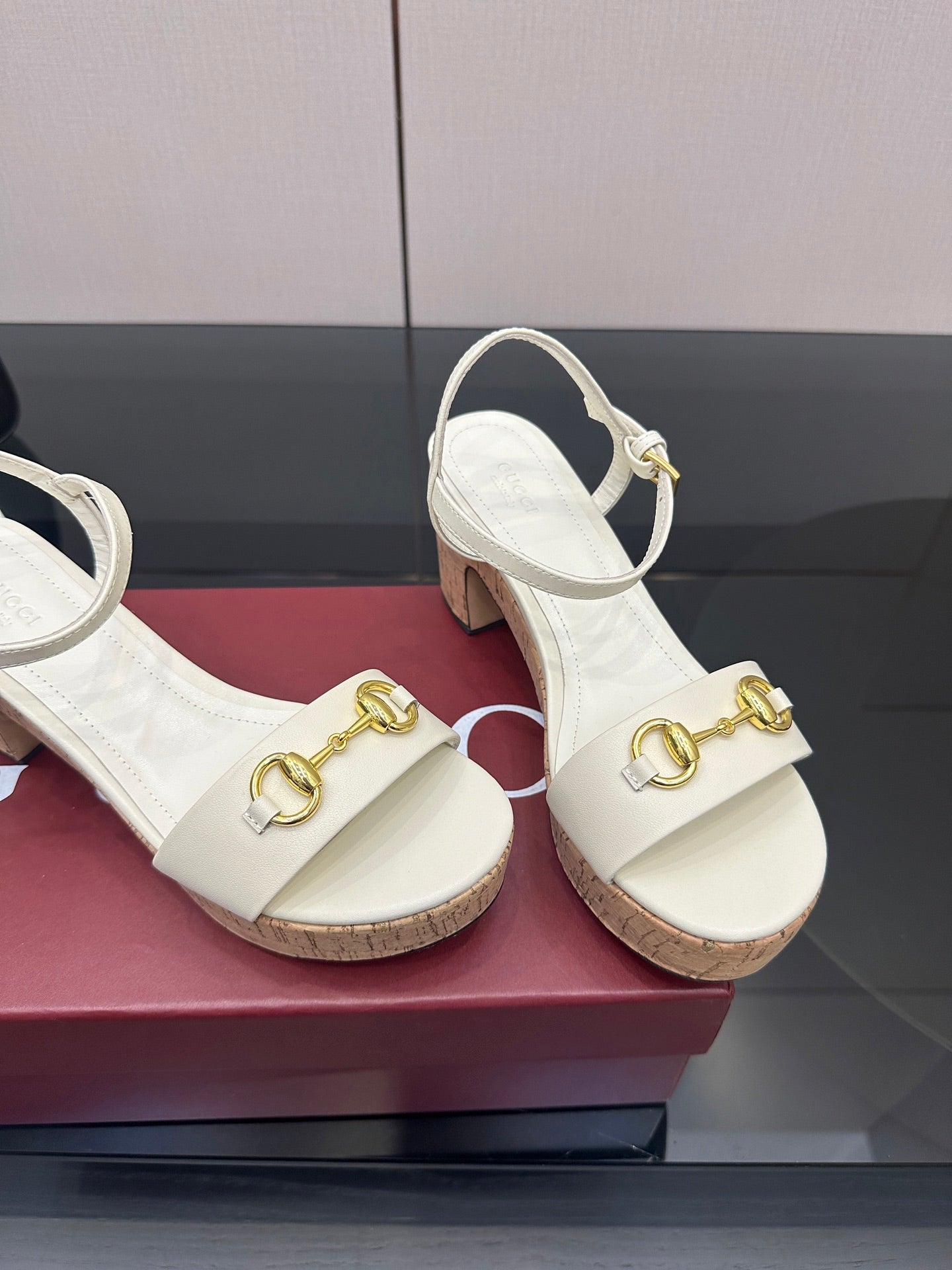 Gucci white heeled slingback sandals close-up with gold horsebit hardware