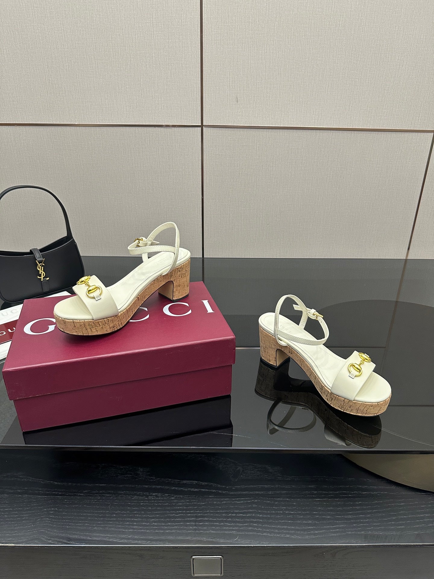 Gucci white heeled sandals with gold horsebit hardware and cork sole, side view
