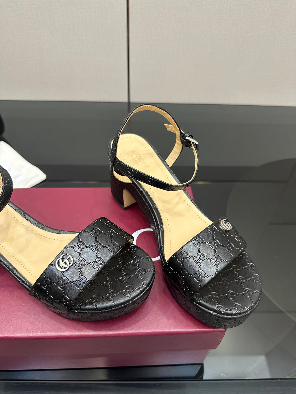 Gucci black leather-look sandals with ankle strap and GG logo pattern