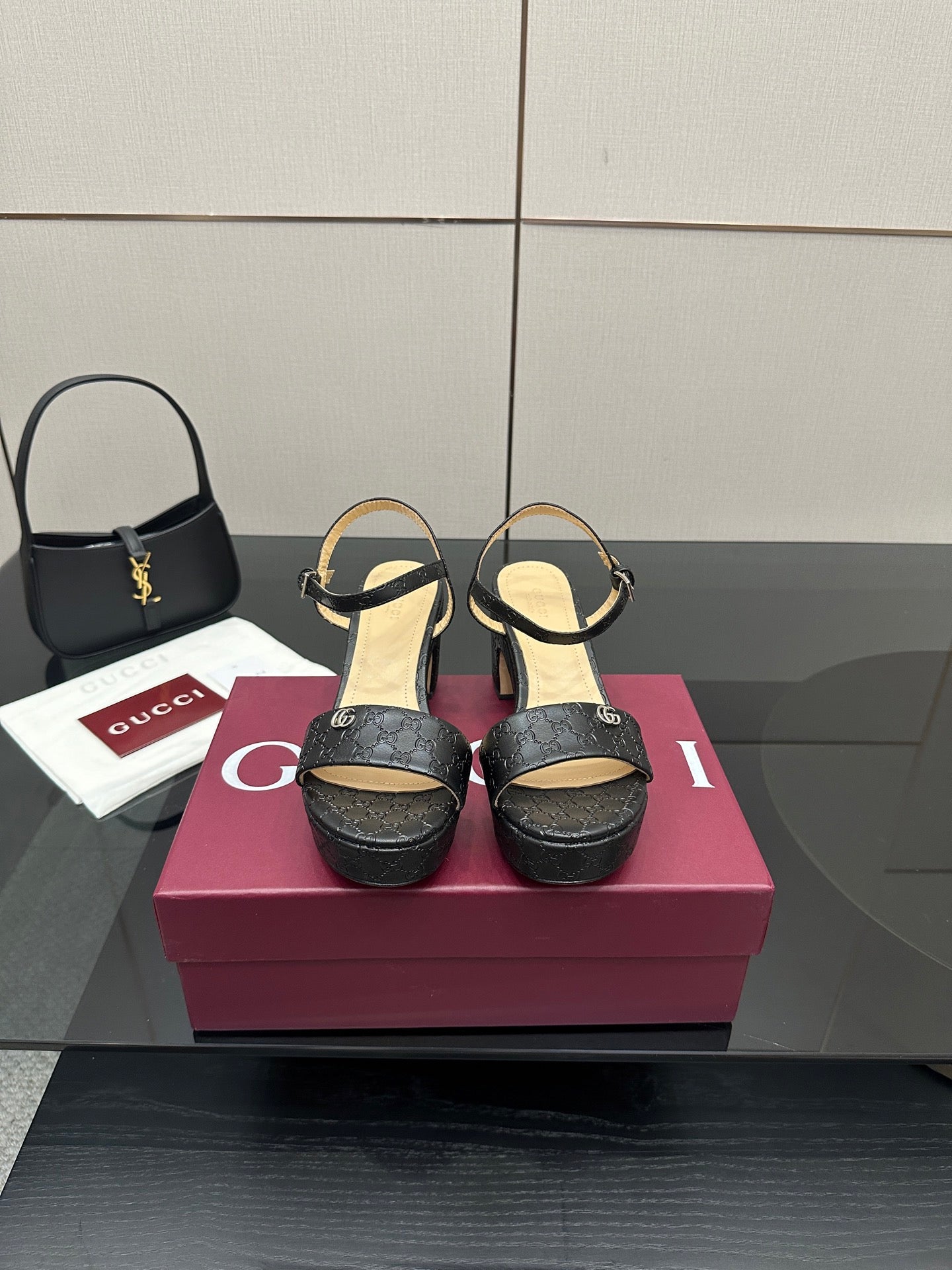 Gucci black platform sandals with ankle strap and textured GG logo pattern