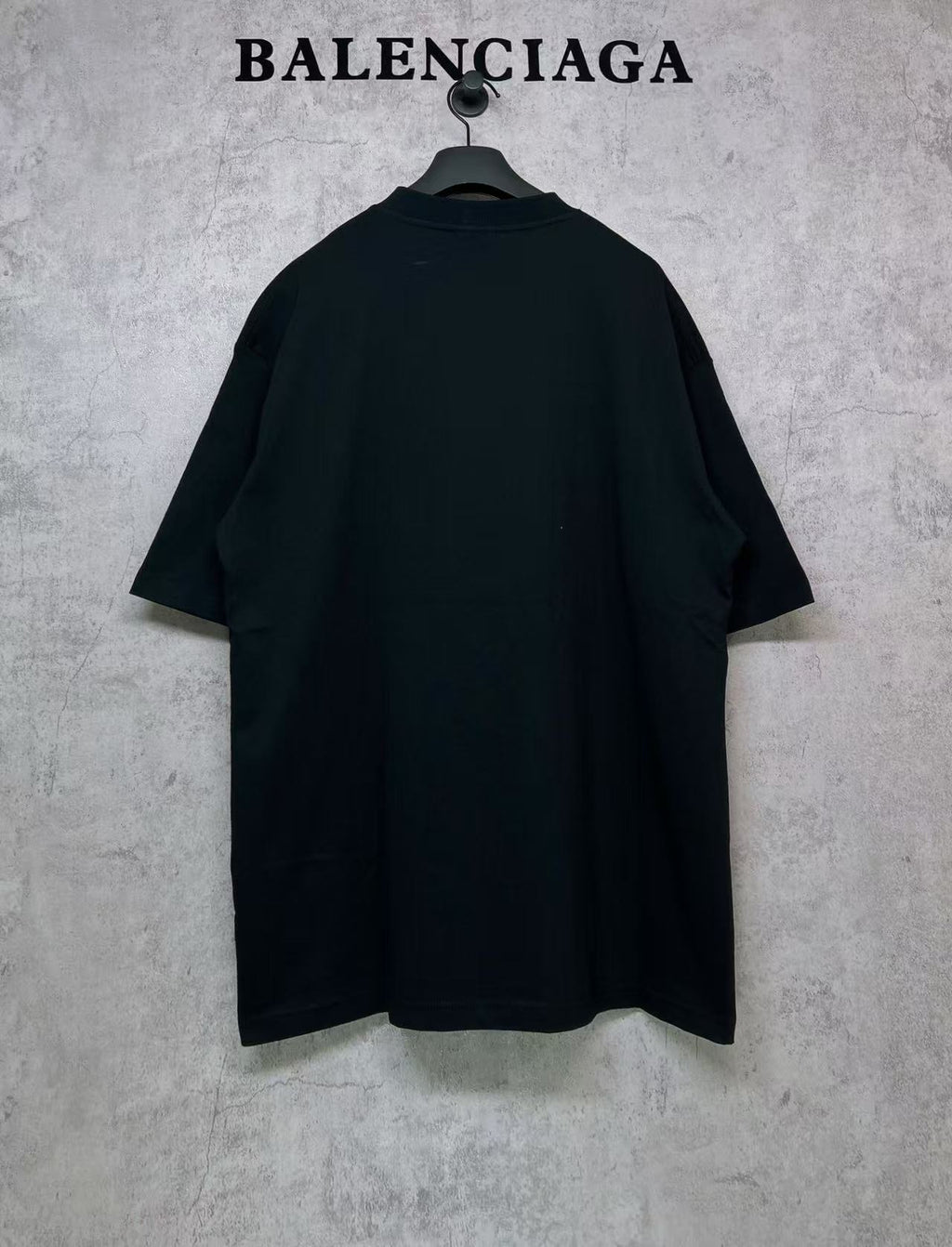 Black T-shirt, back view, hanging on a hanger