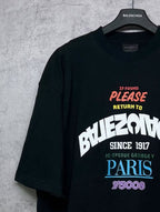 Black T-shirt close-up front graphic with “PLEASE RETURN TO PARIS”