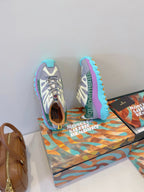 Moncler sneakers pair on box: white-gray uppers with teal lining and bright blue sole