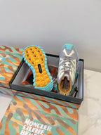 Moncler sneakers with blue textured outsoles, white-gray uppers, green collar, laces