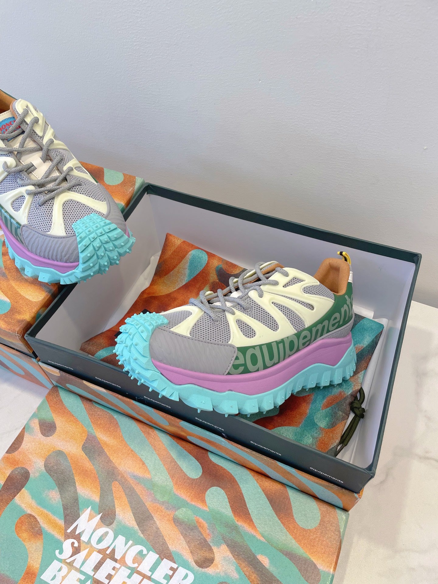 Moncler sneakers in box: white-gray mesh with green panels, pink outsole edge, teal tread