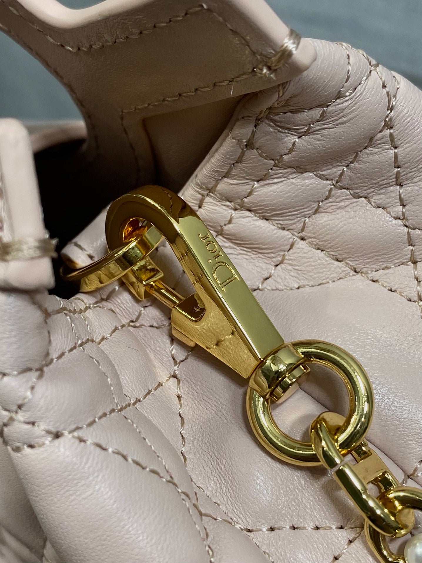 Dior gold-tone lobster clasp and ring on pale pink quilted leather