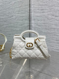 Dior quilted mini handbag with top handle, gold clasp, and detachable wrist strap