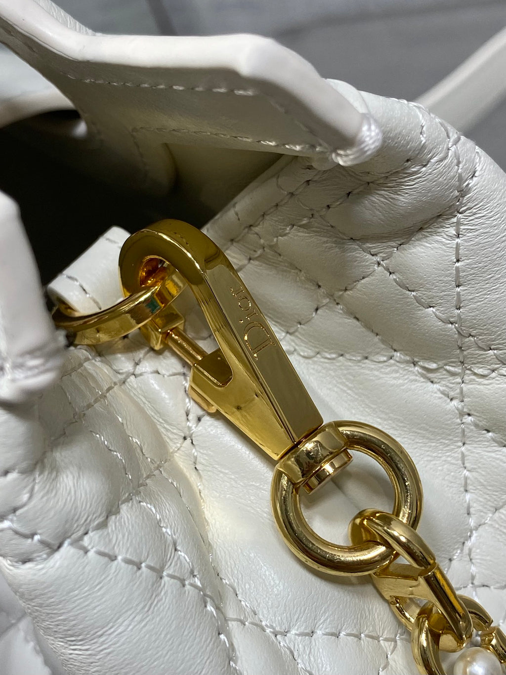 Dior quilted mini handbag close-up of gold clasp hardware and keyring detail