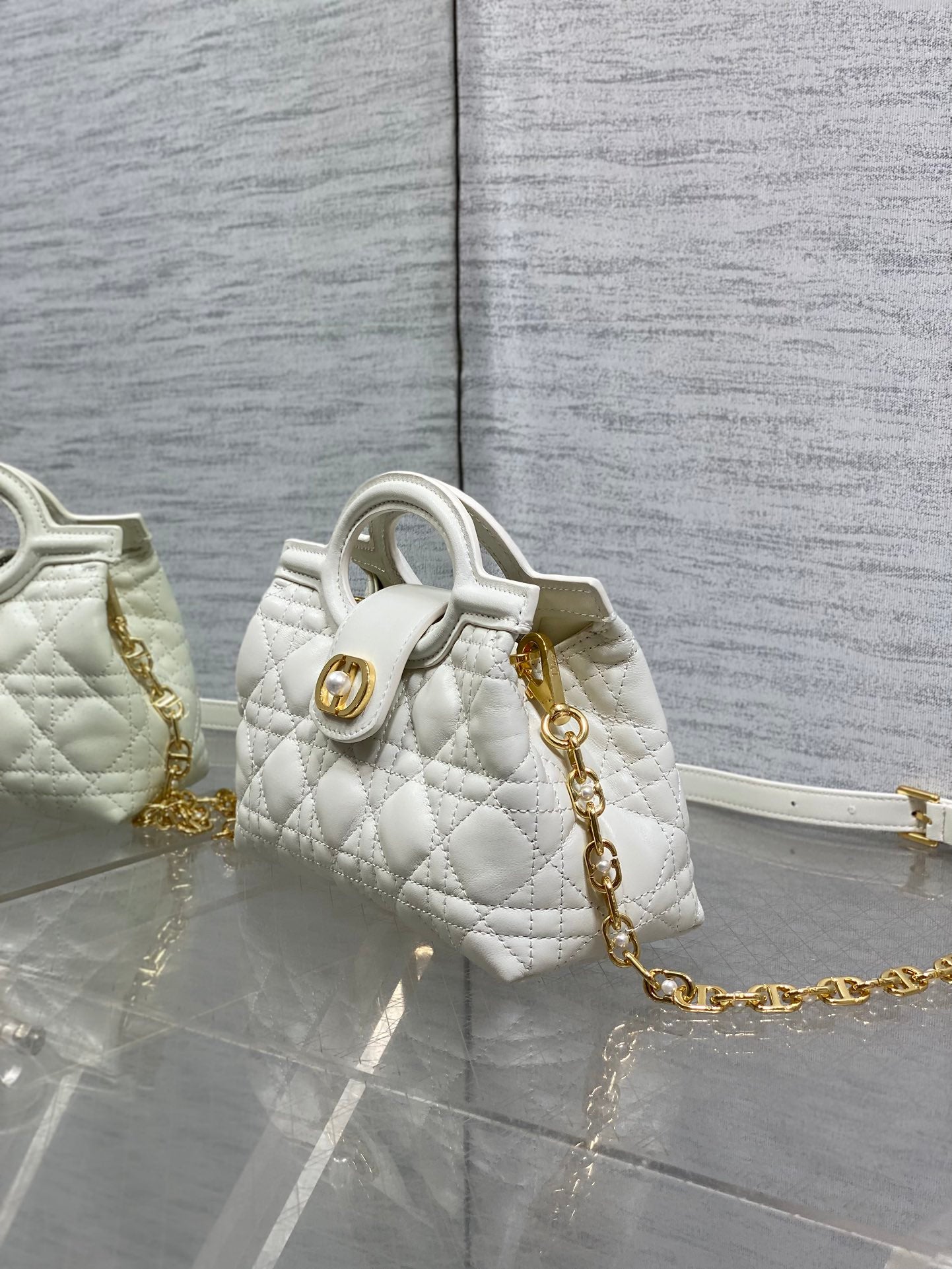 Dior quilted mini handbag with top handle, gold chain strap, and matching side detail