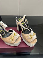 Close-up of beige and gold platform sandals with chunky heel and gold buckle strap detail