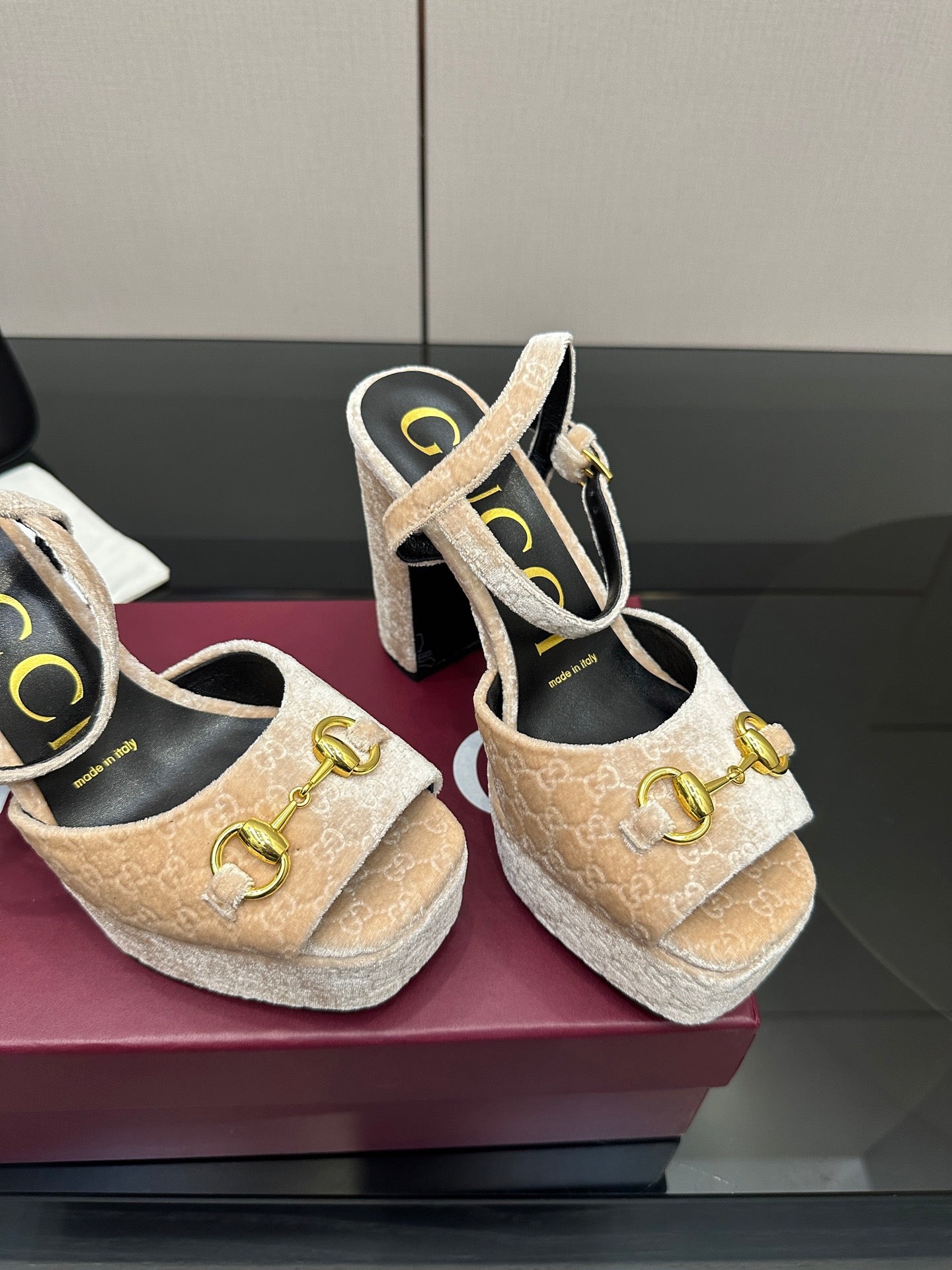 Close-up of beige and gold platform sandals with chunky heel and gold buckle strap detail