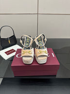 Beige and gold platform sandals with chunky heels, sling straps, and gold buckle accents