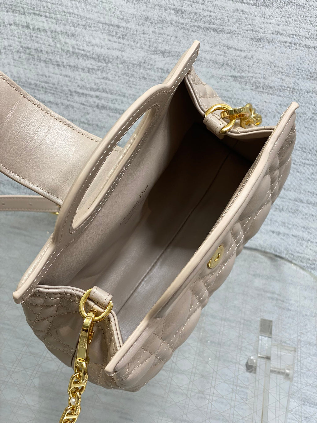 Beige quilted mini handbag interior view with open top and gold-toned hardware