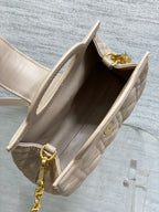 Beige quilted mini handbag interior view with open top and gold-toned hardware
