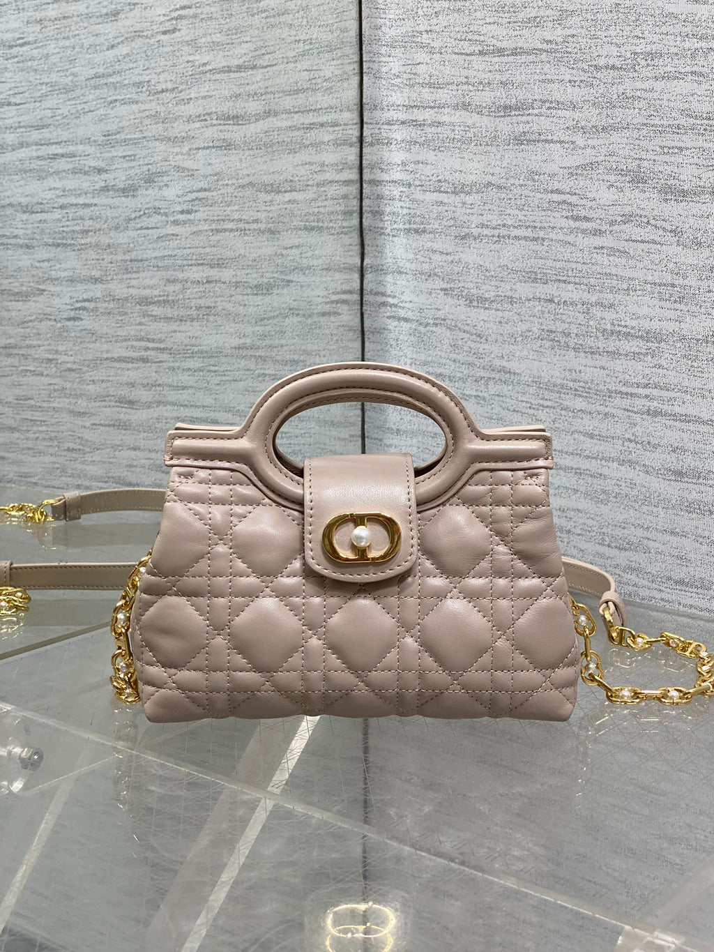 Beige quilted mini handbag with top handle and gold chain strap