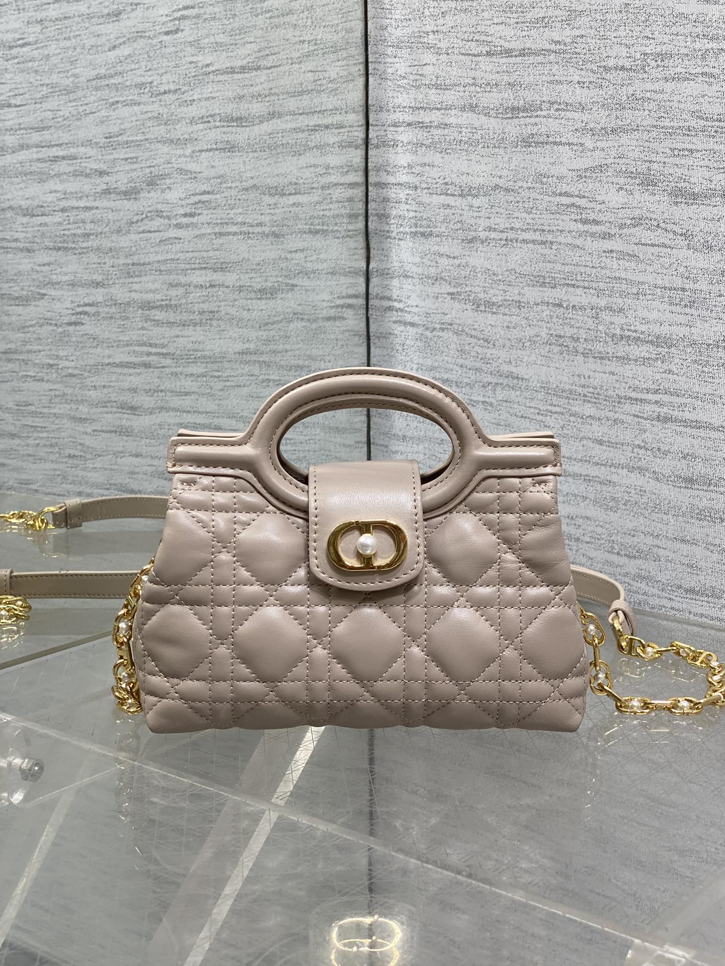 Beige quilted mini handbag with top handle and gold chain strap