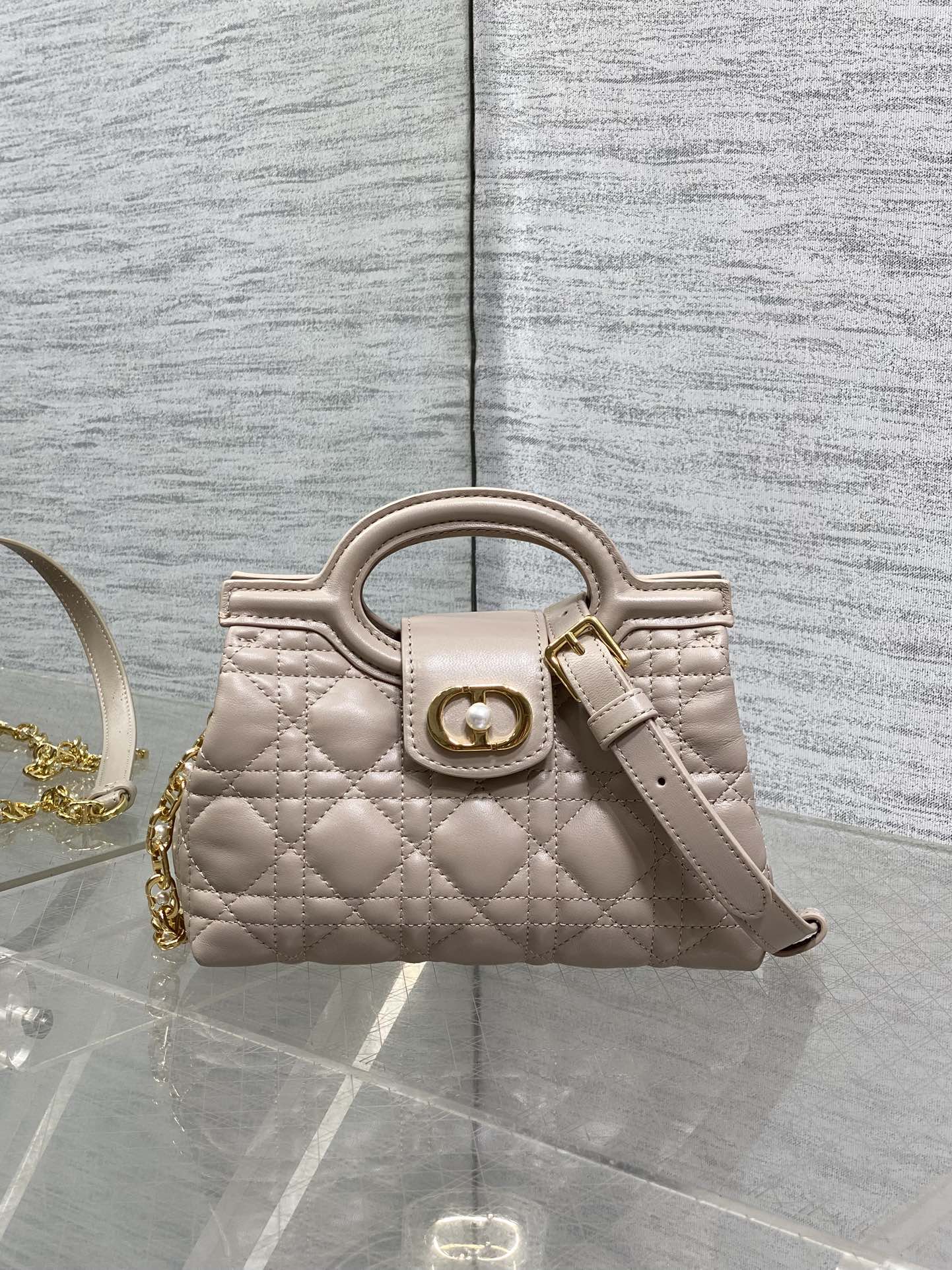 Beige quilted mini handbag with top handle and gold-tone clasp