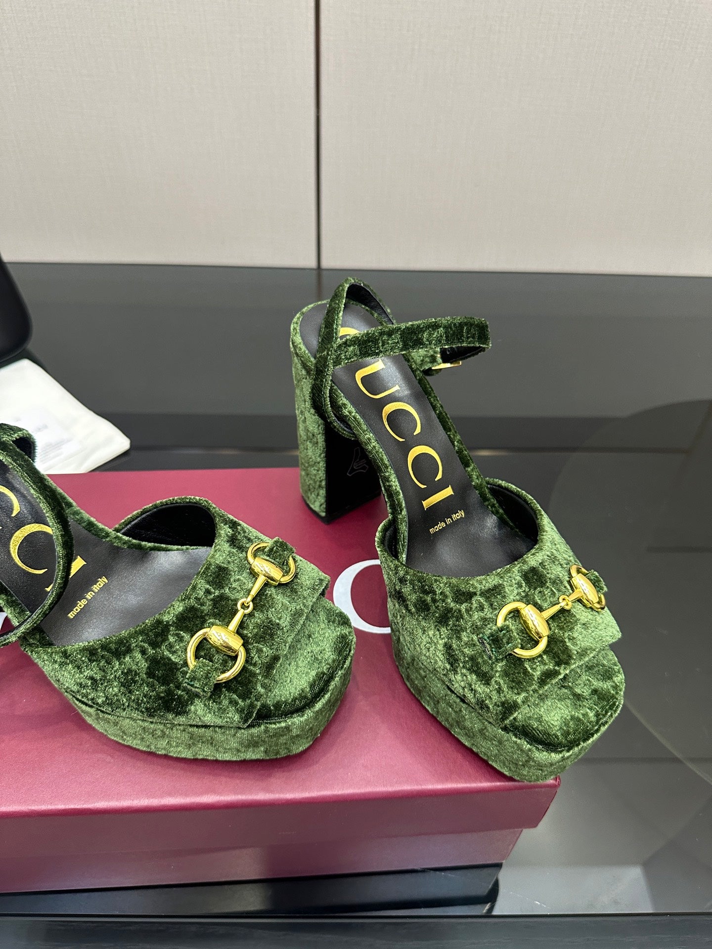 Gucci ladies green patterned platform heels, close-up of gold-tone hardware and straps