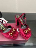 Pair of red velvet platform heels with gold buckle and thick block heels, close-up