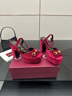 Red velvet platform heels with gold buckle accents and chunky block heel, angled