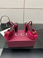 Red velvet platform heels with gold buckle detail and ankle strap, front-left view