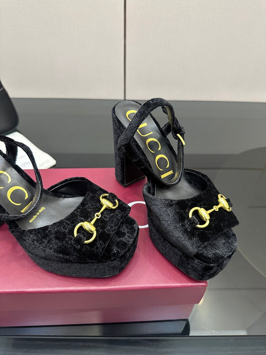 Close view of Gucci women’s black heeled mules with gold buckle accent and block heel
