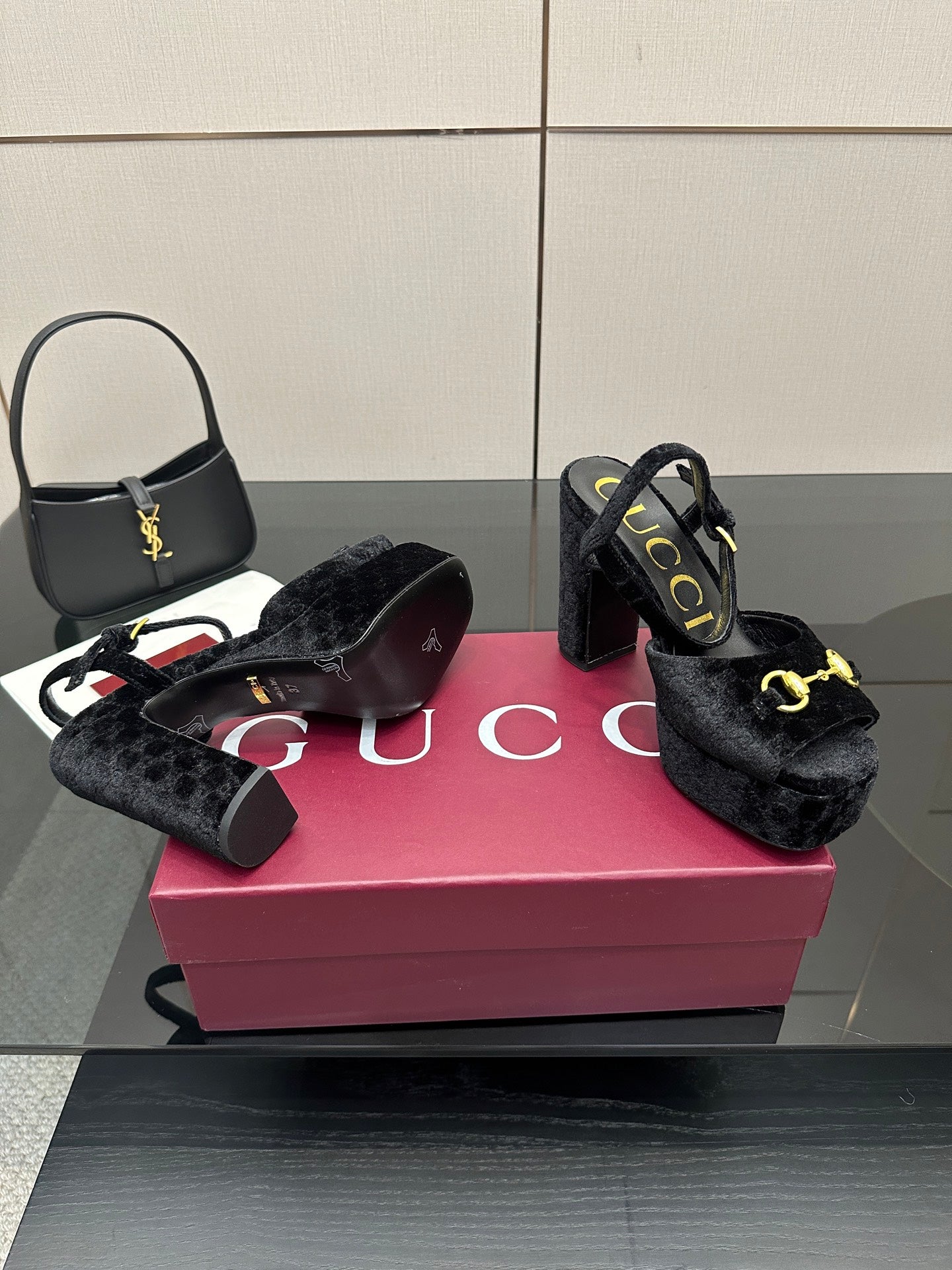 Pair of Gucci women’s black heeled mules with gold buckle trim and thick platform