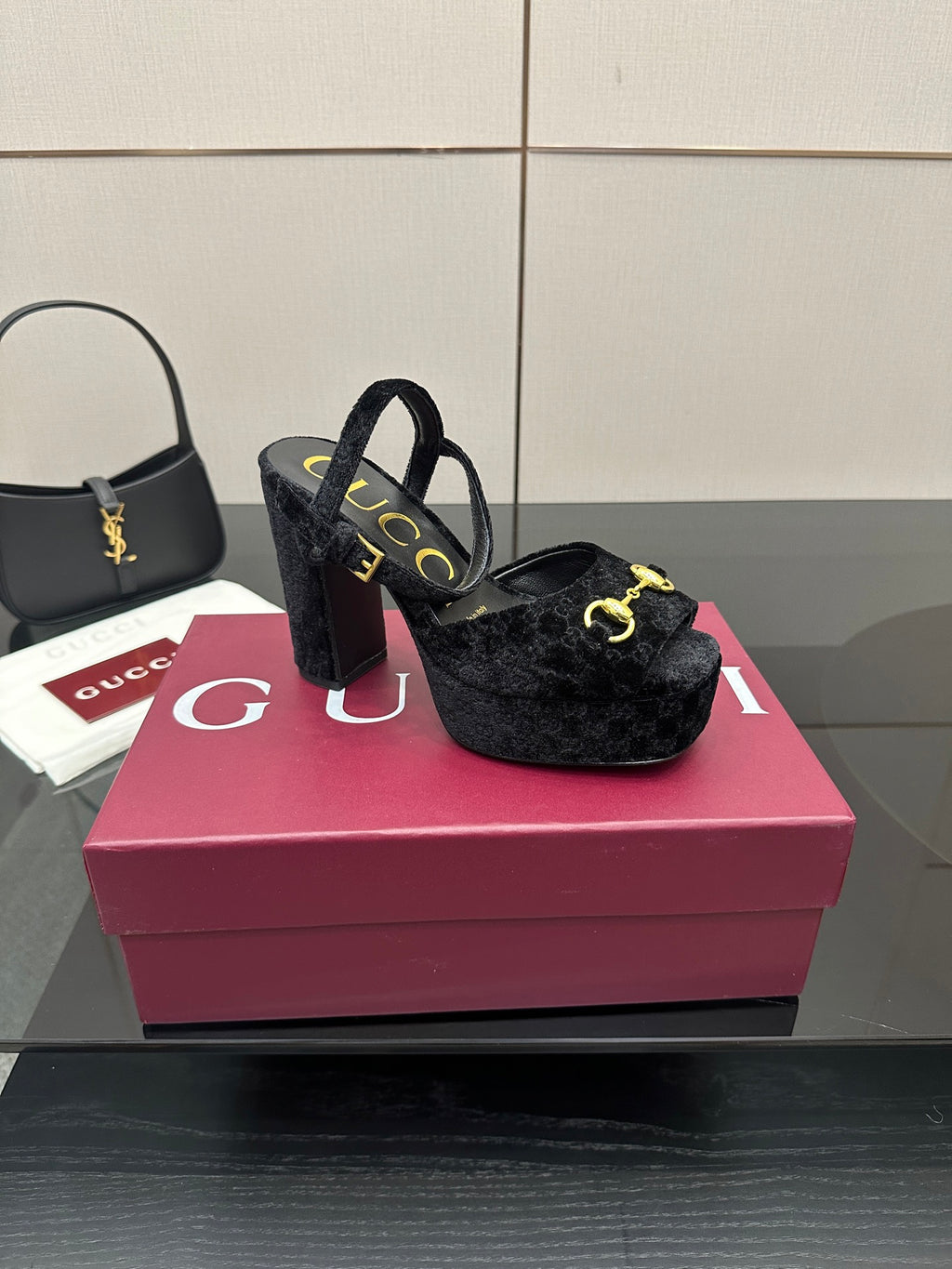 Gucci women’s black heeled mules with gold buckle accents and open-toe design