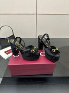 Gucci women’s black heeled mules with gold horseshoe buckle detail and open toe