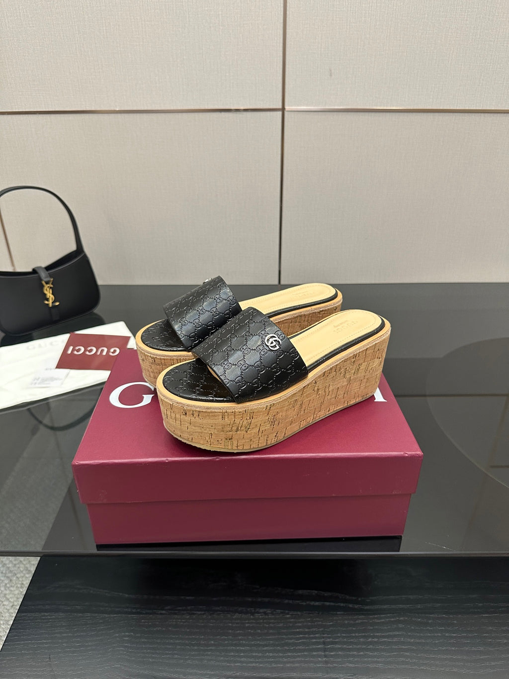 Gucci black GG slide sandals with cork wedge sole and wide strap, gold logo