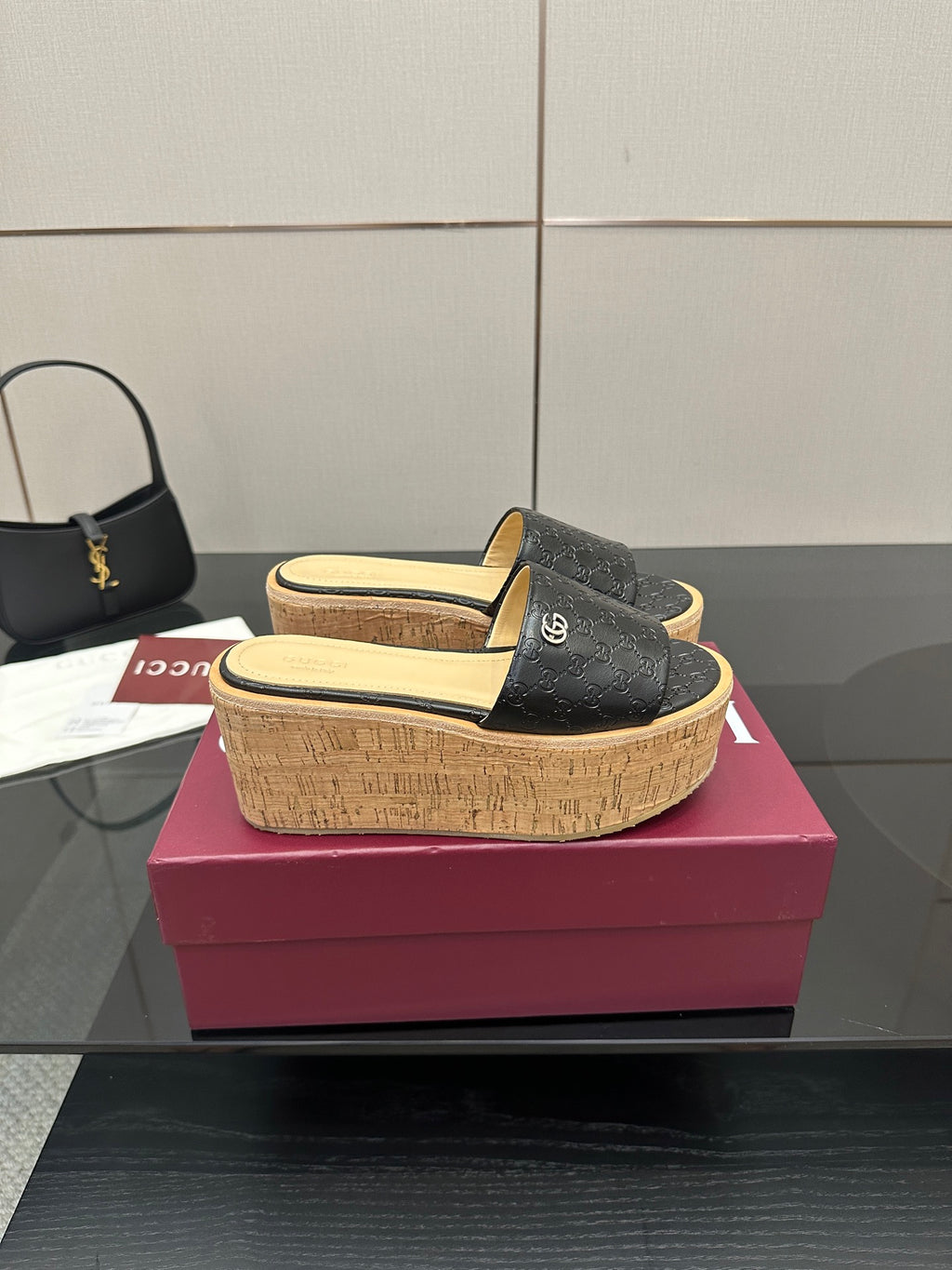 Gucci black GG slide sandals with cork wedge platform and gold logo on strap
