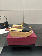 Gucci black GG slide sandals with cork wedge platform and gold logo on strap