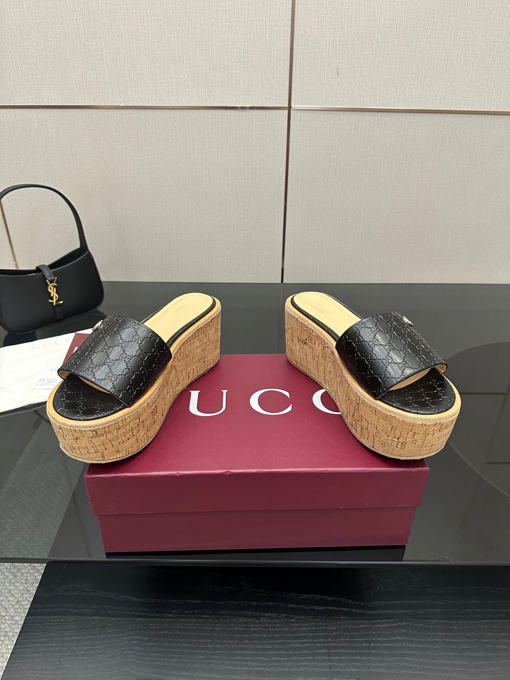 Gucci black GG platform slide sandals with cork wedge sole and gold logo emblem