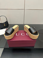 Gucci black GG platform slide sandals with cork wedge sole and gold logo emblem