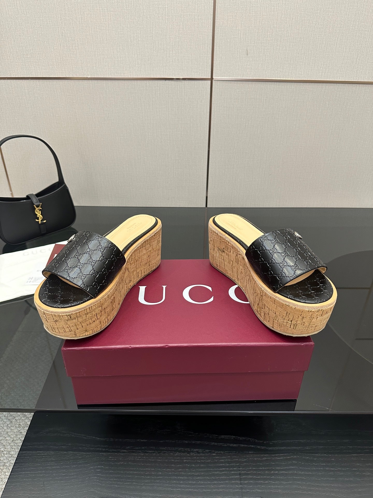 Gucci black GG platform slide sandals with cork wedge sole and gold logo emblem