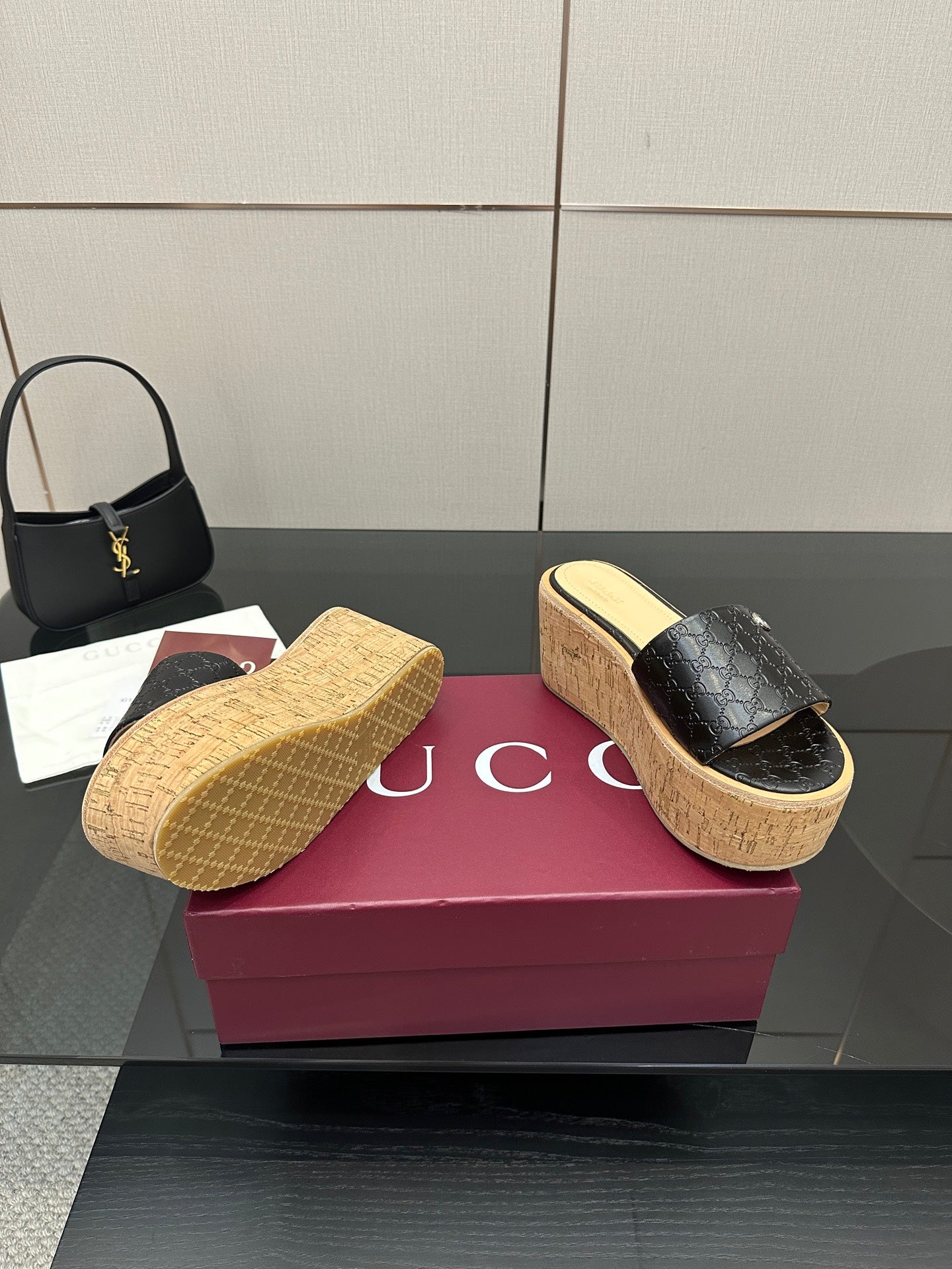 Gucci black GG slide sandals on cork wedge platform with textured sole