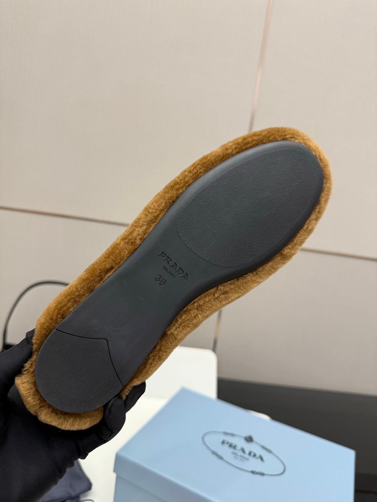 Women's tan suede flat sole, sidewall and branding stamp visible