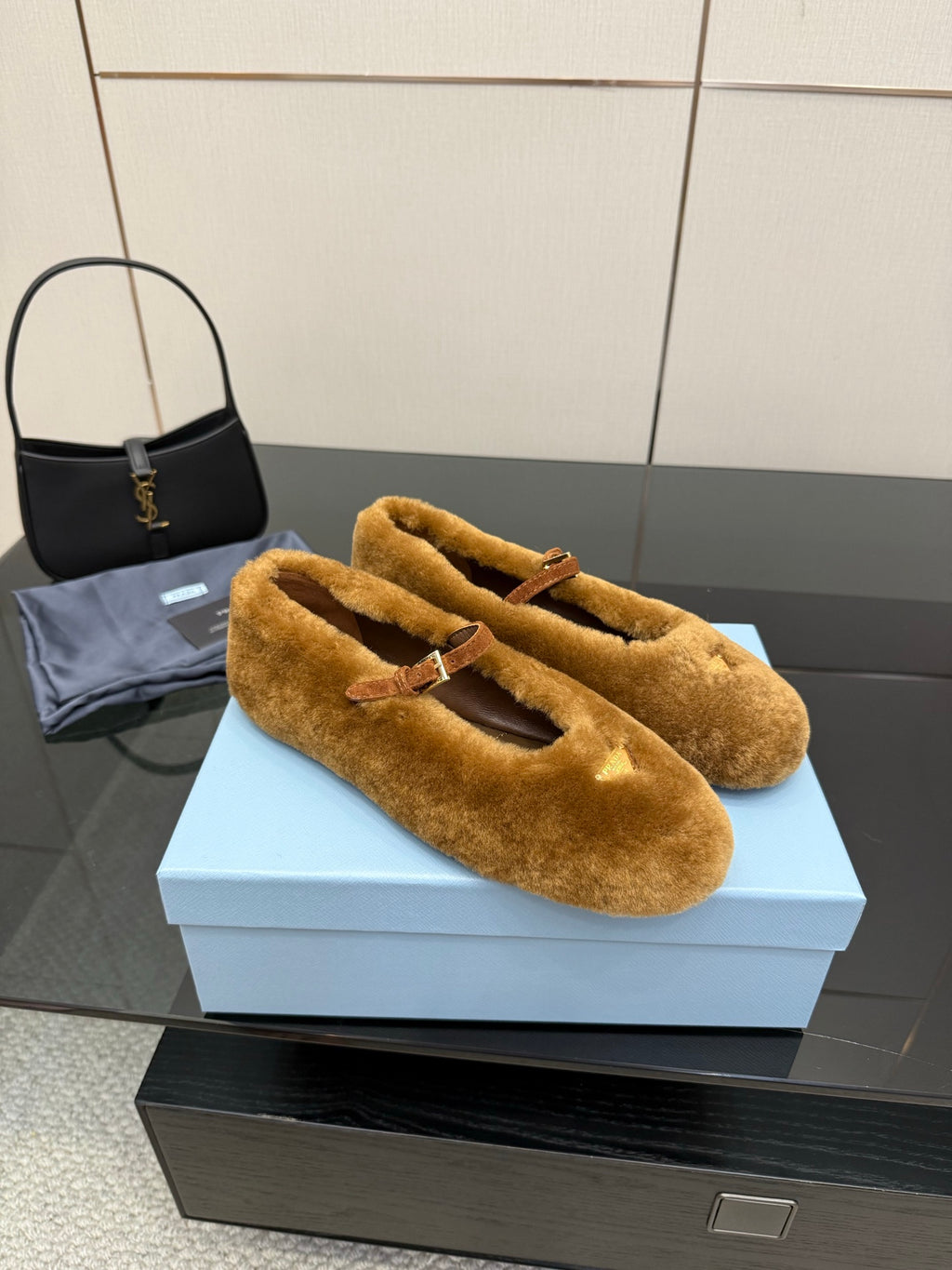 Women's tan suede flats with buckle strap and branded emblem detail
